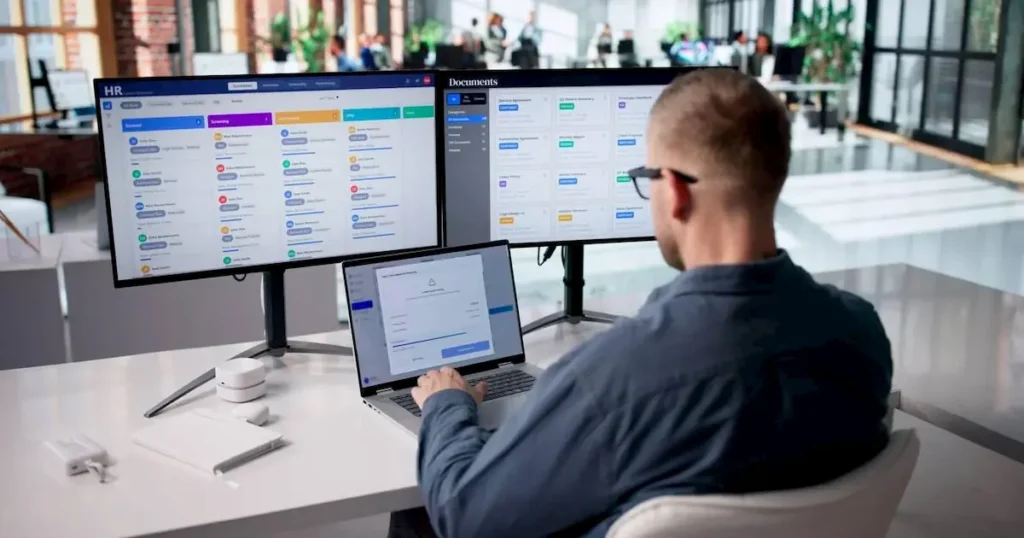 Accountant Analyzing Payroll Data Across Several Monitors 